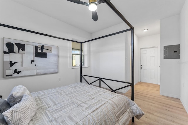 bedroom with hardwood / wood-style flooring, ceiling fan, and electric panel