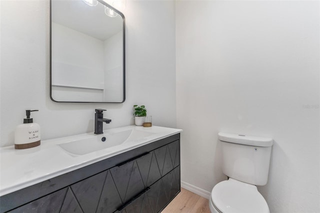 bathroom featuring vanity, toilet, and hardwood / wood-style floors