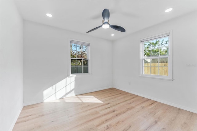 empty room with ceiling fan and light hardwood / wood-style flooring