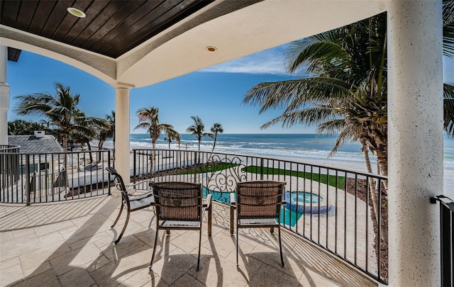 balcony with a water view and a beach view