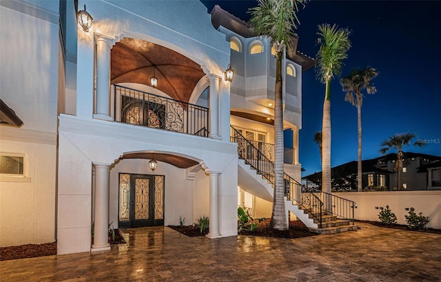 exterior entry at night featuring a balcony