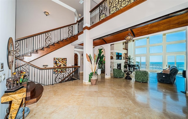 interior space featuring a water view, ornamental molding, and a high ceiling