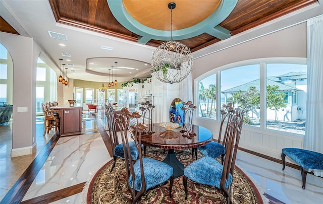 dining space with a raised ceiling, crown molding, coffered ceiling, and a notable chandelier