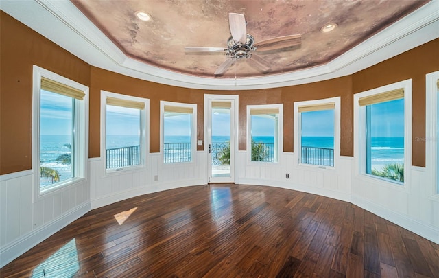 interior space featuring a water view, ceiling fan, and a tray ceiling