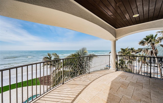 balcony featuring a beach view and a water view