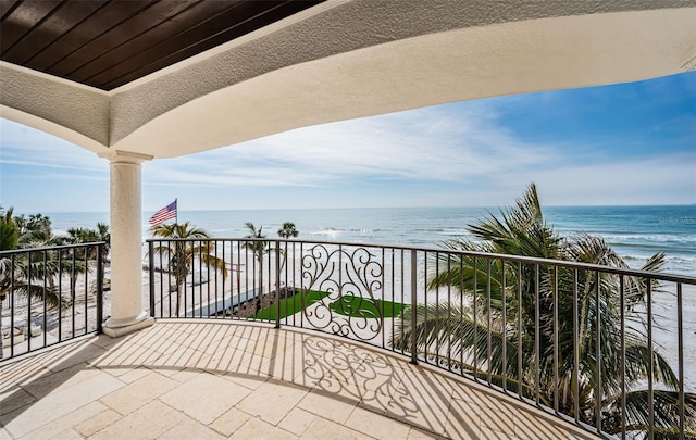 balcony featuring a beach view and a water view