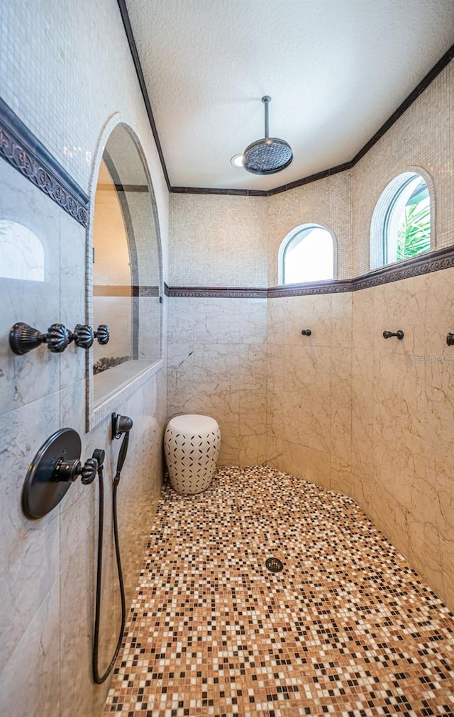 bathroom featuring crown molding, a textured ceiling, and tiled shower