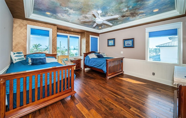 bedroom featuring ornamental molding, dark hardwood / wood-style flooring, and a tray ceiling