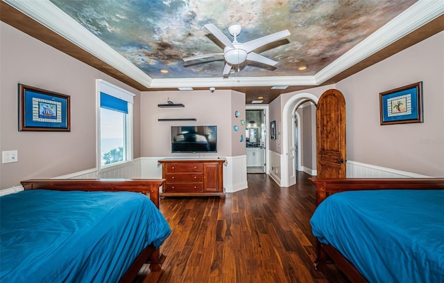 bedroom featuring dark wood-type flooring, ornamental molding, and a tray ceiling