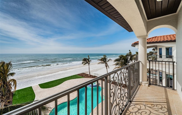 balcony featuring a view of the beach and a water view