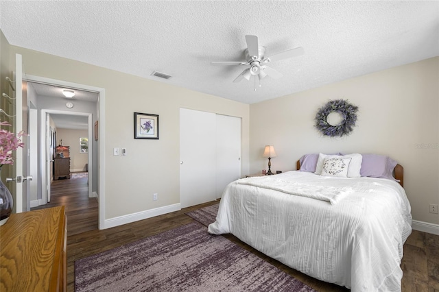 bedroom featuring ceiling fan, dark hardwood / wood-style floors, a textured ceiling, and a closet