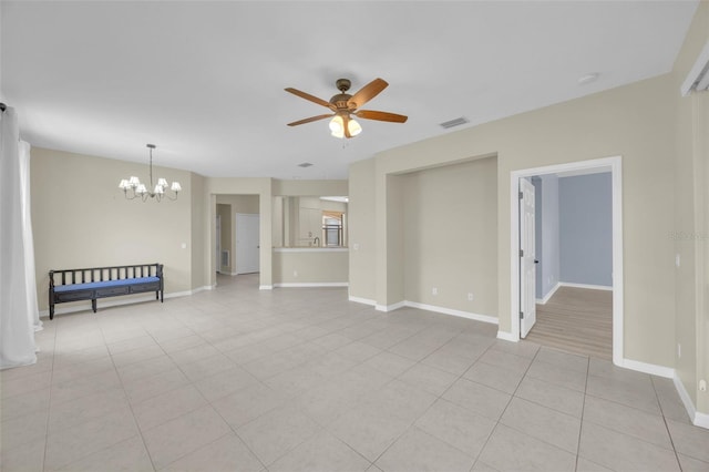 interior space with ceiling fan with notable chandelier and light tile patterned floors