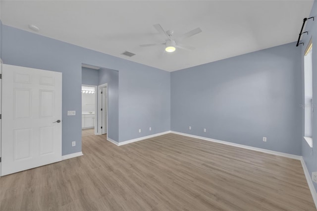 spare room with ceiling fan and light wood-type flooring