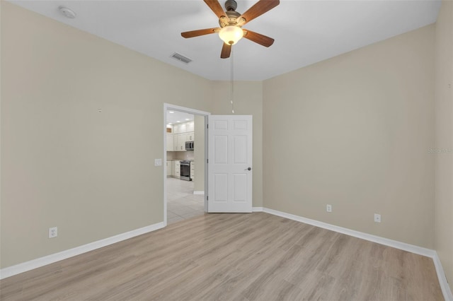 spare room featuring ceiling fan and light wood-type flooring