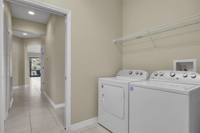 laundry room with independent washer and dryer and light tile patterned floors