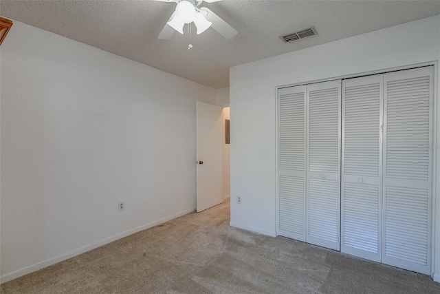 unfurnished bedroom featuring carpet, a closet, visible vents, and a textured ceiling