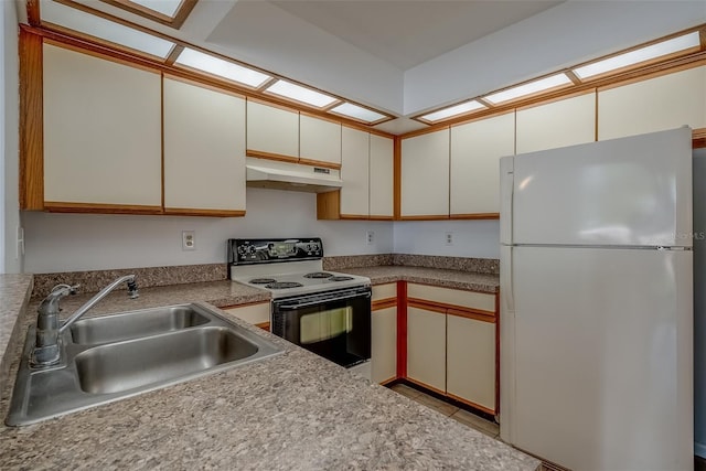 kitchen with range with electric cooktop, white cabinets, freestanding refrigerator, under cabinet range hood, and a sink