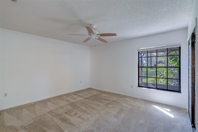 unfurnished room featuring a textured ceiling, carpet, and a ceiling fan