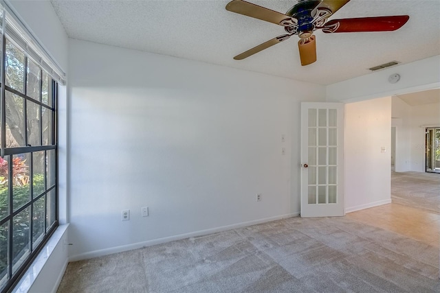 spare room with visible vents, carpet flooring, ceiling fan, a textured ceiling, and baseboards