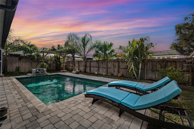 pool at dusk featuring a patio area