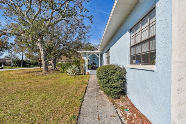 view of side of property with a lawn