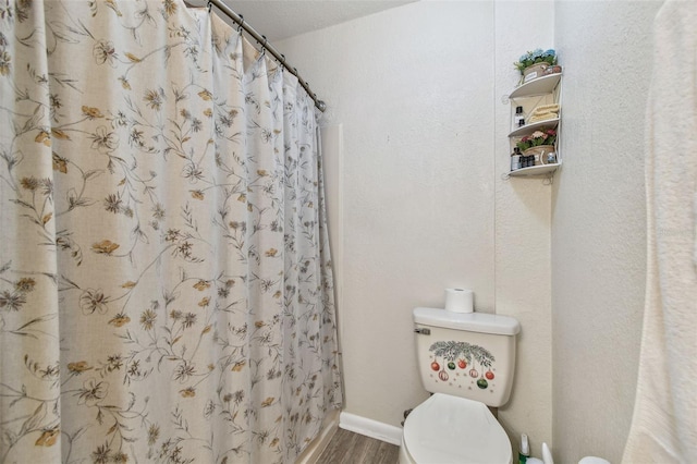 bathroom with hardwood / wood-style flooring and toilet