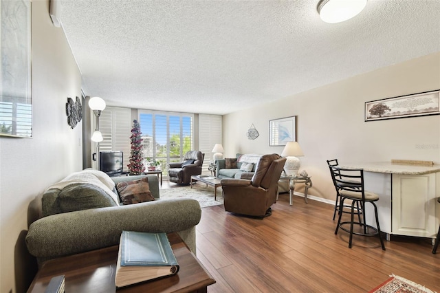 living room with dark hardwood / wood-style flooring, floor to ceiling windows, and a textured ceiling