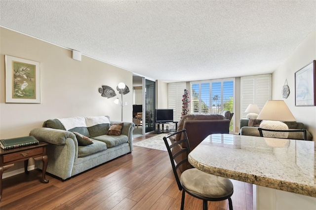 living room with a wall of windows, dark hardwood / wood-style floors, and a textured ceiling