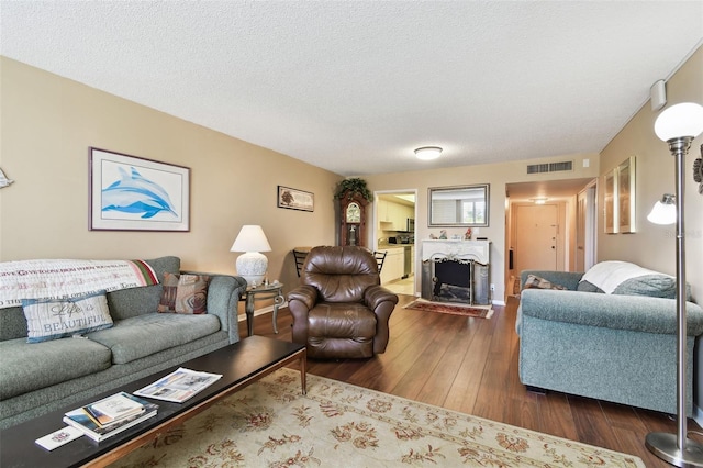 living room featuring dark hardwood / wood-style flooring and a textured ceiling