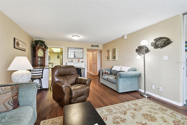 living room featuring dark hardwood / wood-style floors and a textured ceiling