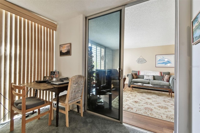 dining space with floor to ceiling windows and a textured ceiling