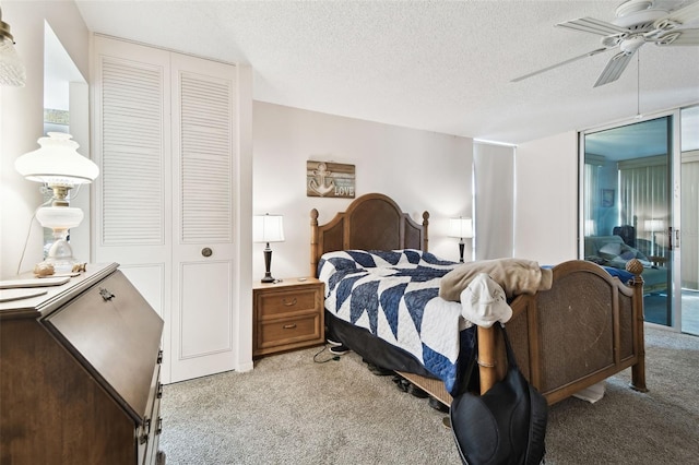 carpeted bedroom with ceiling fan, a closet, and a textured ceiling