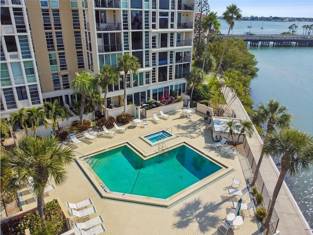 view of swimming pool with a community hot tub, a patio, and a water view