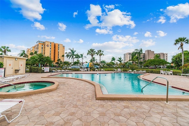 view of pool with a hot tub and a patio area