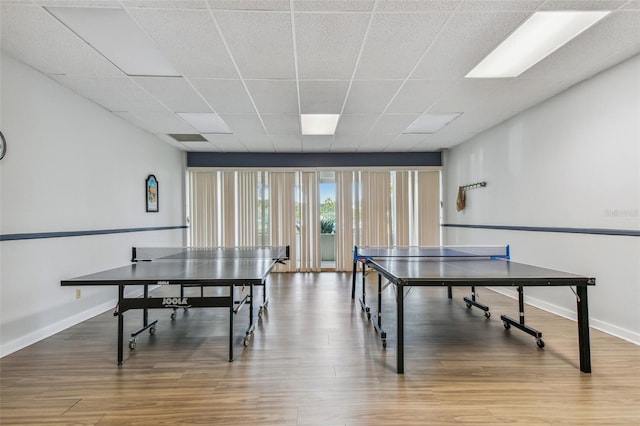 game room with a drop ceiling and hardwood / wood-style floors