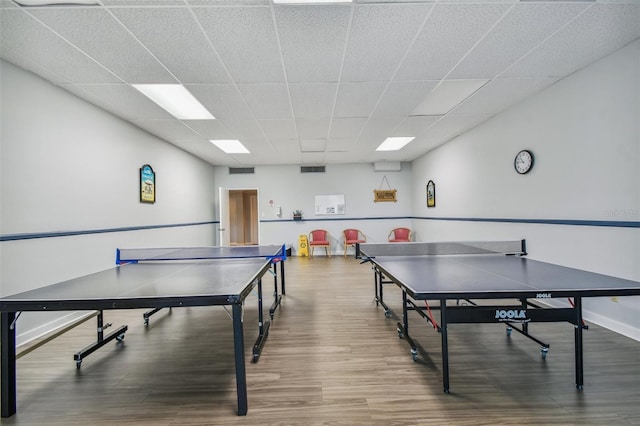 playroom with wood-type flooring and a drop ceiling