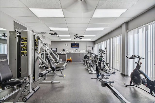 workout area featuring ceiling fan and a paneled ceiling