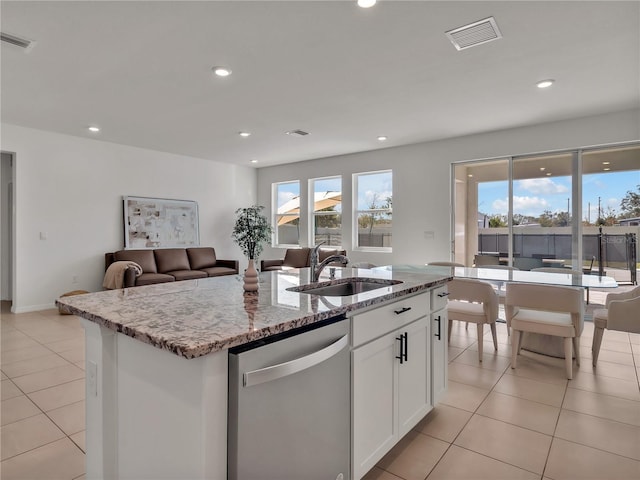 kitchen with sink, dishwasher, a kitchen island with sink, light stone countertops, and white cabinets