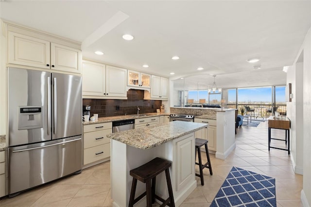 kitchen featuring a breakfast bar, kitchen peninsula, a kitchen island, stainless steel appliances, and backsplash