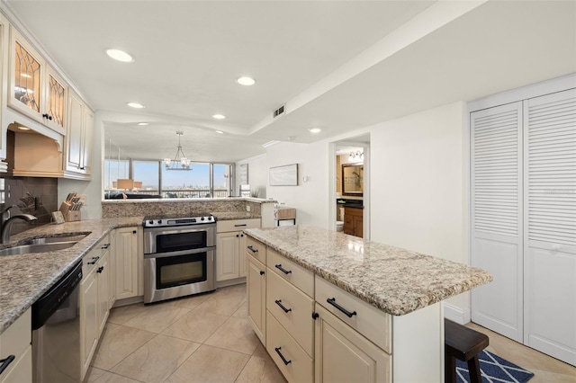 kitchen with a breakfast bar, sink, hanging light fixtures, a kitchen island, and stainless steel appliances