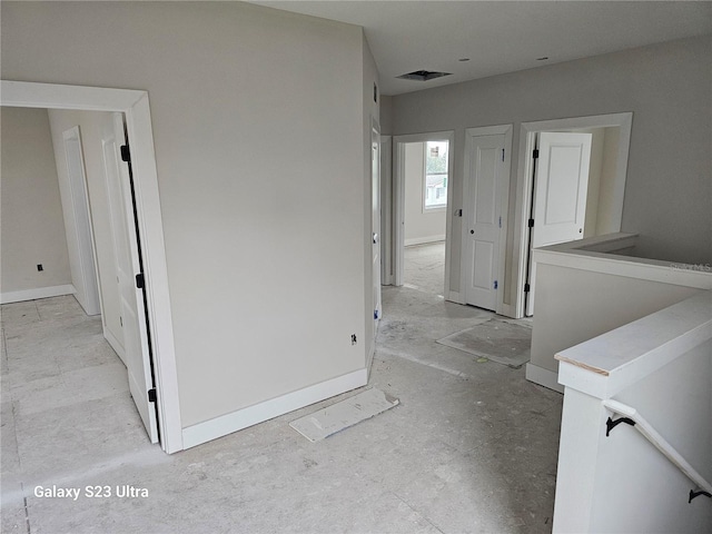 interior space featuring an upstairs landing, visible vents, and baseboards