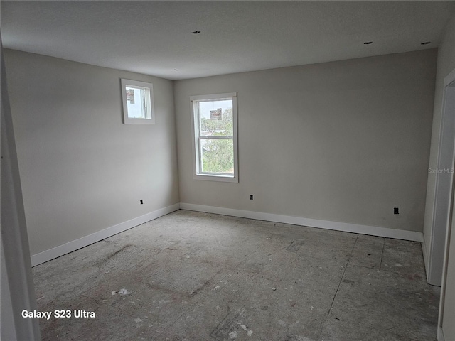 unfurnished room with baseboards