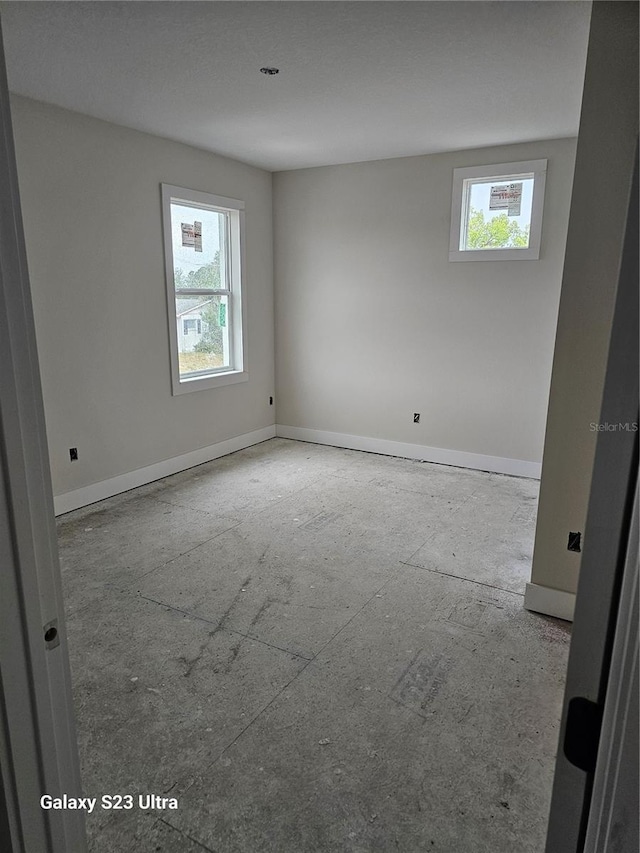 unfurnished room with a healthy amount of sunlight and baseboards