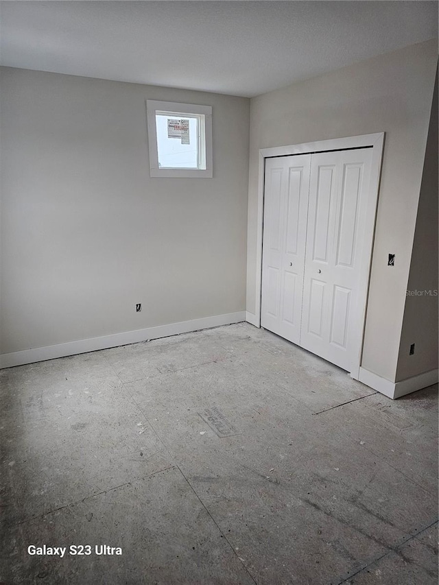 unfurnished bedroom with a closet and baseboards