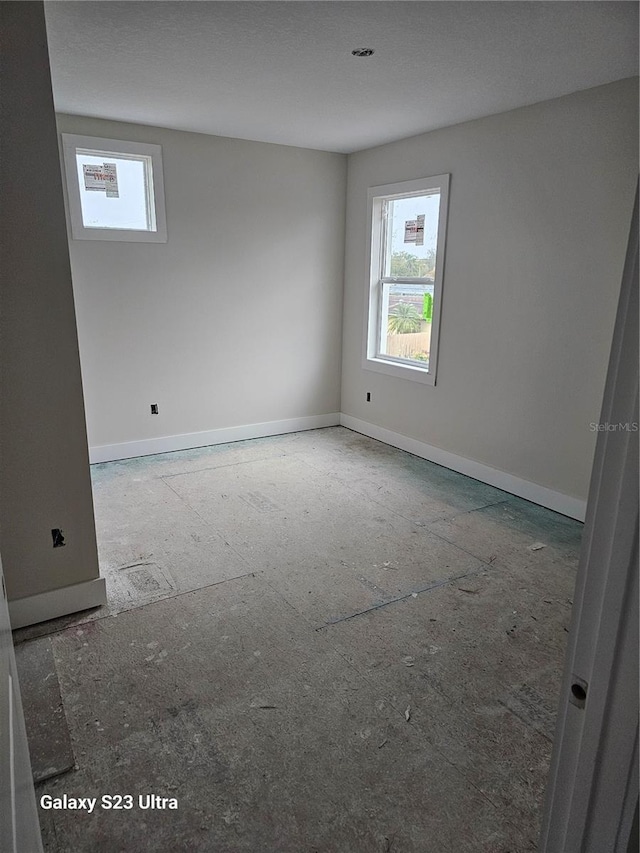 unfurnished room with baseboards