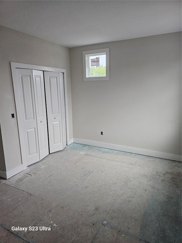 unfurnished bedroom with a closet and baseboards