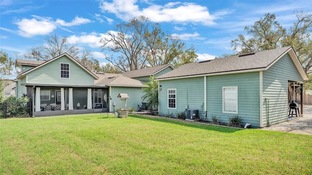 rear view of house with a yard, central AC, and a sunroom