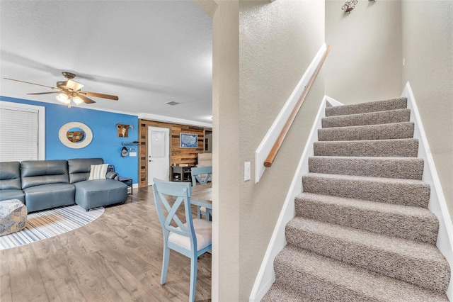 stairway featuring hardwood / wood-style flooring and ceiling fan