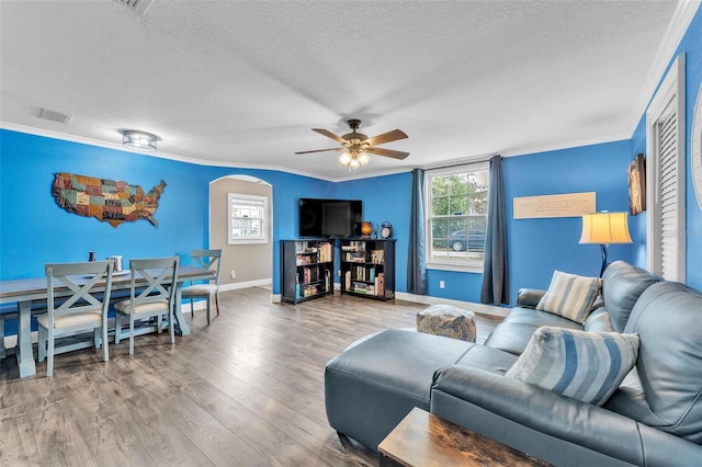 living room with crown molding, ceiling fan, hardwood / wood-style floors, and a textured ceiling