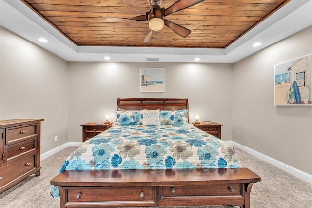 bedroom featuring ceiling fan, light colored carpet, wood ceiling, and a tray ceiling